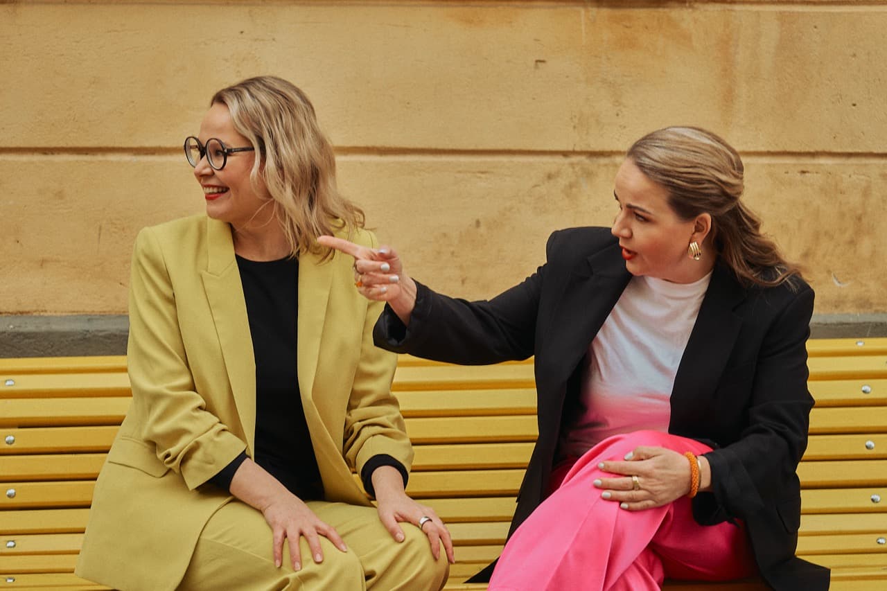 Two professionals in conversation on a yellow bench